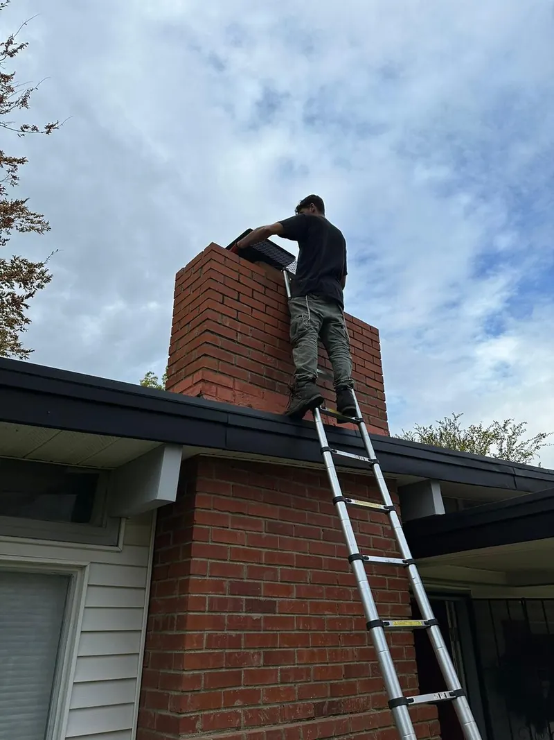 Ladder set to the roofline for a roof-level chimney inspection