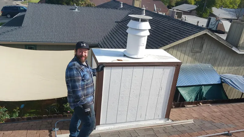 Alpine Chimney technician at roof level beside a chase top and flue cap