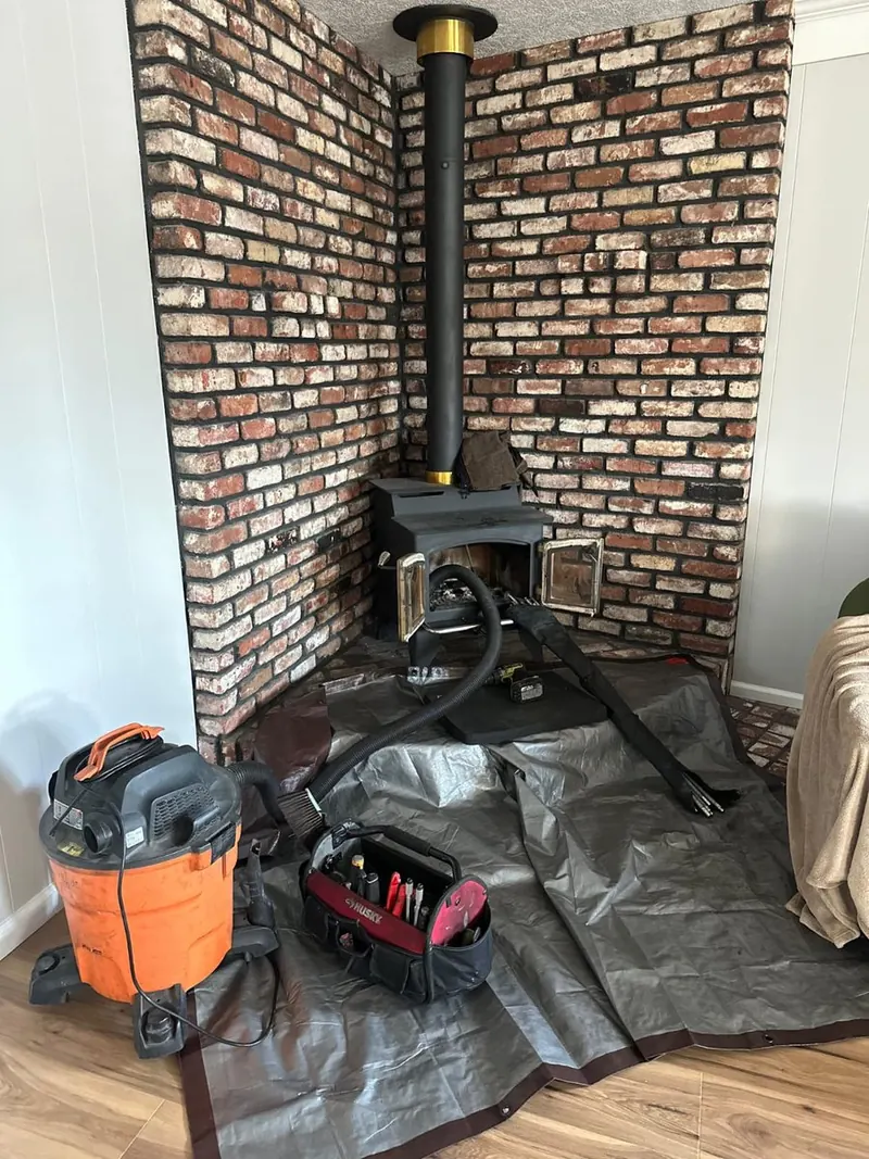 Wood stove flue swept in a brick alcove